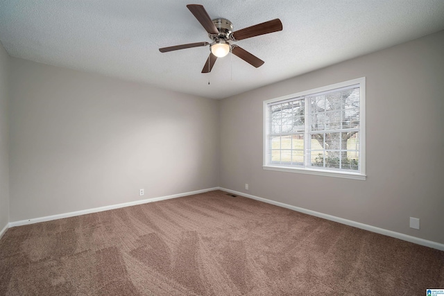 empty room featuring carpet floors, ceiling fan, baseboards, and a textured ceiling