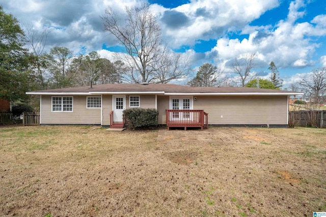 back of house featuring fence, a lawn, and a wooden deck