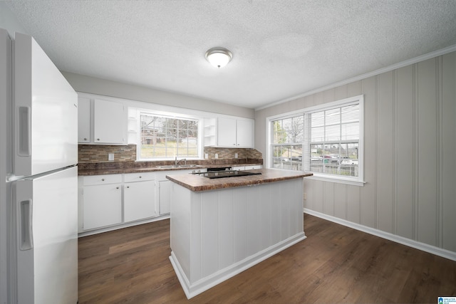 kitchen with dark countertops, dark wood-type flooring, a wealth of natural light, and freestanding refrigerator