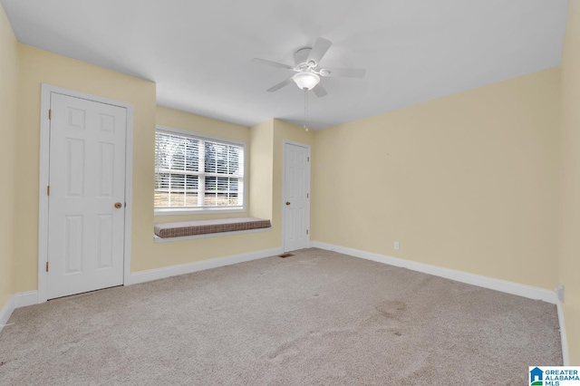 empty room featuring a ceiling fan, baseboards, and carpet flooring