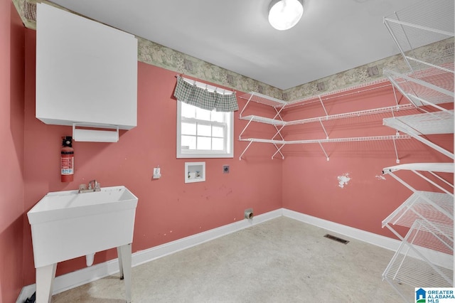 laundry area featuring hookup for a washing machine, laundry area, a sink, visible vents, and baseboards