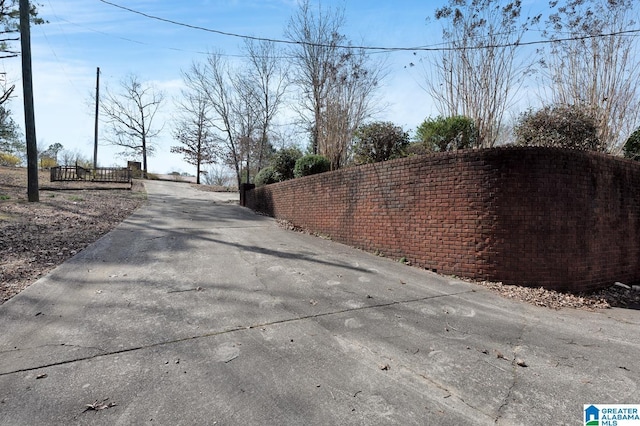 view of street featuring driveway and a gated entry