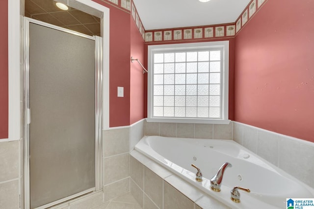 bathroom featuring a stall shower and a tub with jets