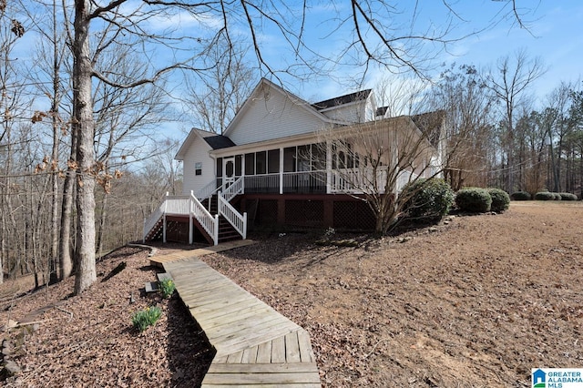 view of front of property featuring a sunroom and stairway