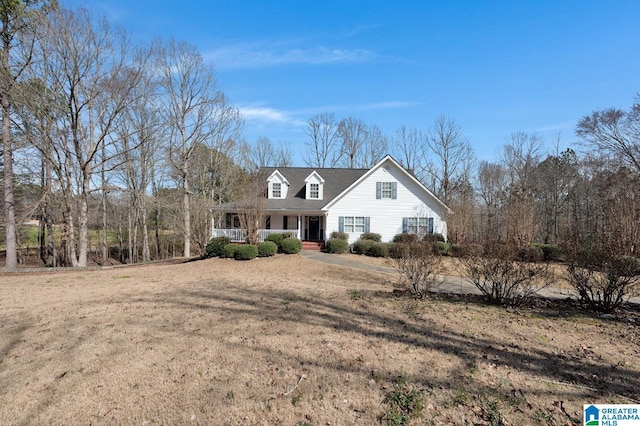 cape cod home featuring covered porch and a front yard