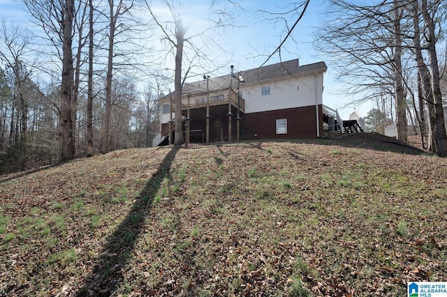 rear view of house with brick siding and stairs