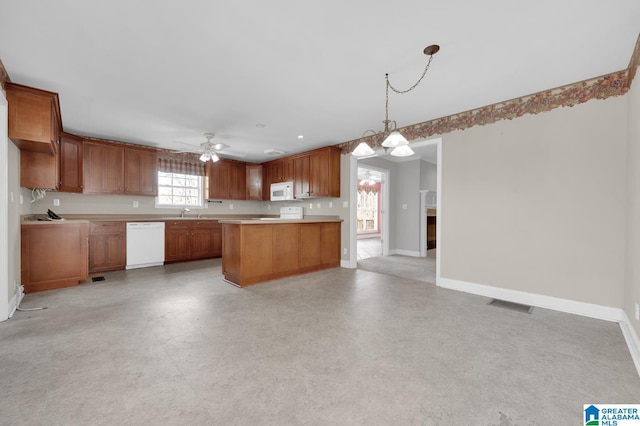 kitchen featuring light countertops, visible vents, open floor plan, white appliances, and baseboards