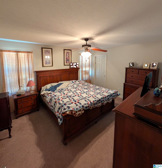 bedroom with a textured ceiling, a ceiling fan, and light carpet