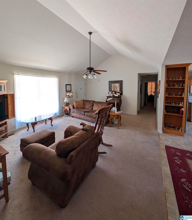 living area with light colored carpet, lofted ceiling, ceiling fan, and a textured ceiling