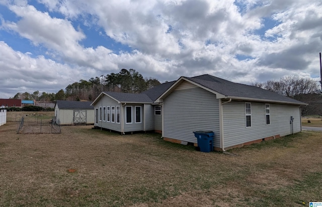 back of property with an outdoor structure, fence, a yard, and a storage shed