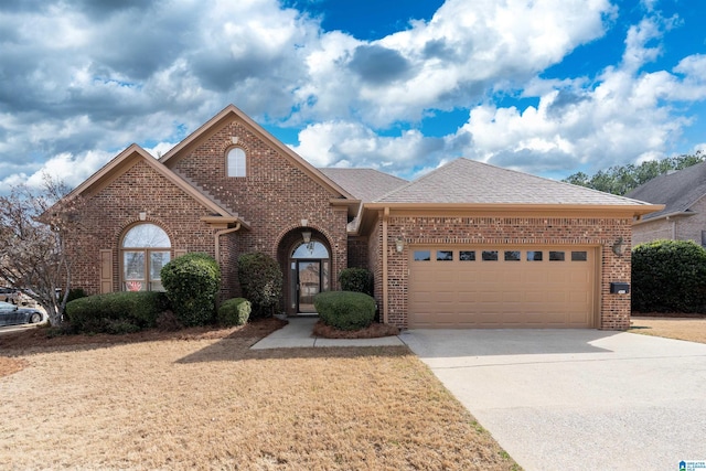 view of front of house featuring driveway, a garage, and brick siding