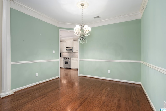 spare room featuring a chandelier, dark wood-type flooring, visible vents, baseboards, and ornamental molding