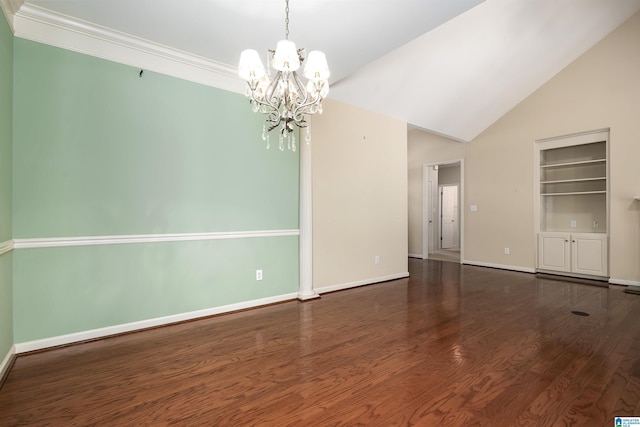 spare room with a chandelier, wood finished floors, baseboards, vaulted ceiling, and crown molding