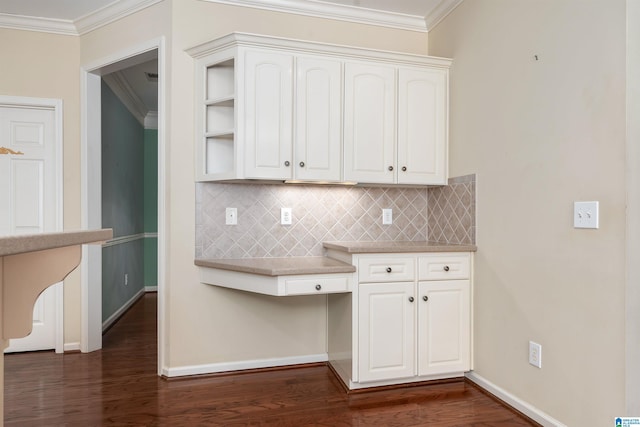 kitchen with dark wood finished floors, crown molding, backsplash, and baseboards