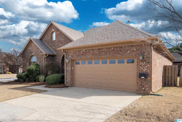 view of front of property featuring a garage, a shingled roof, concrete driveway, and brick siding