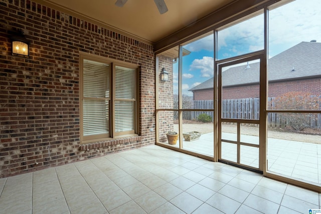 unfurnished sunroom with ceiling fan