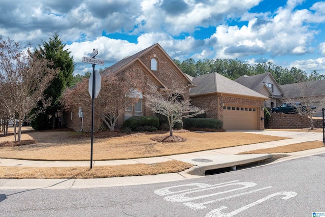 view of front of house with a garage, driveway, a shingled roof, and brick siding