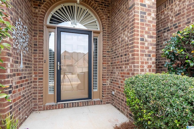 doorway to property featuring brick siding