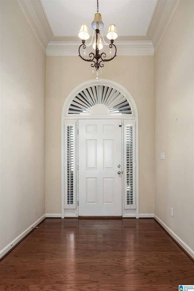 entryway with baseboards, a notable chandelier, ornamental molding, and wood finished floors