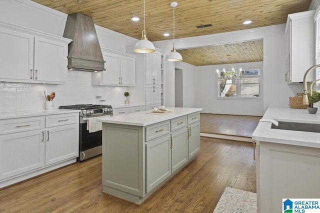 kitchen with a sink, wood ceiling, custom exhaust hood, and gas range