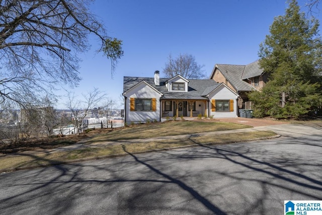 view of front of house featuring a chimney and fence