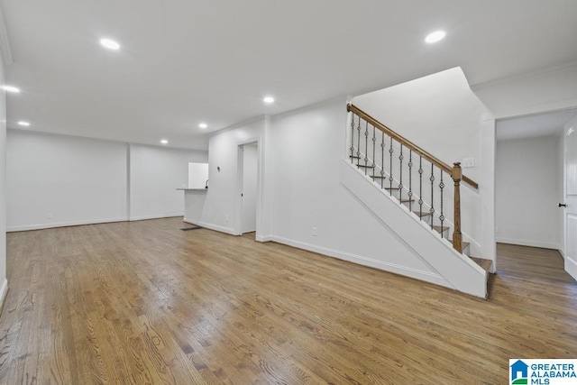 below grade area with recessed lighting, wood finished floors, baseboards, and stairs