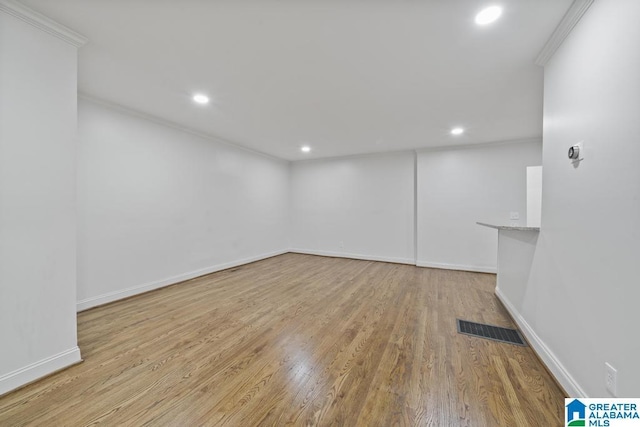 basement with recessed lighting, visible vents, crown molding, and wood finished floors