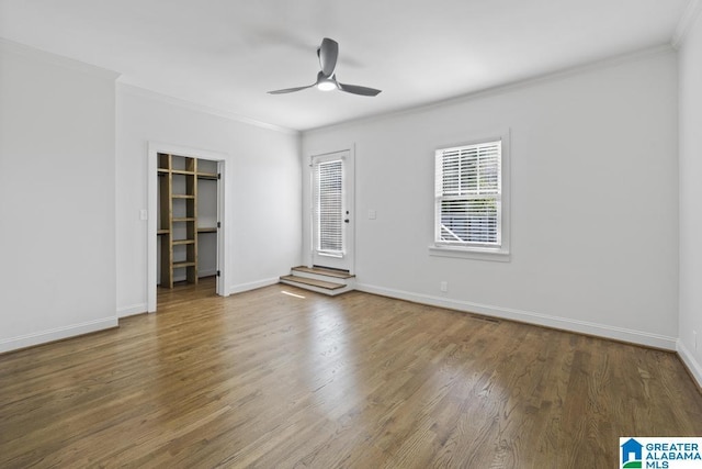 spare room featuring baseboards, ornamental molding, and wood finished floors