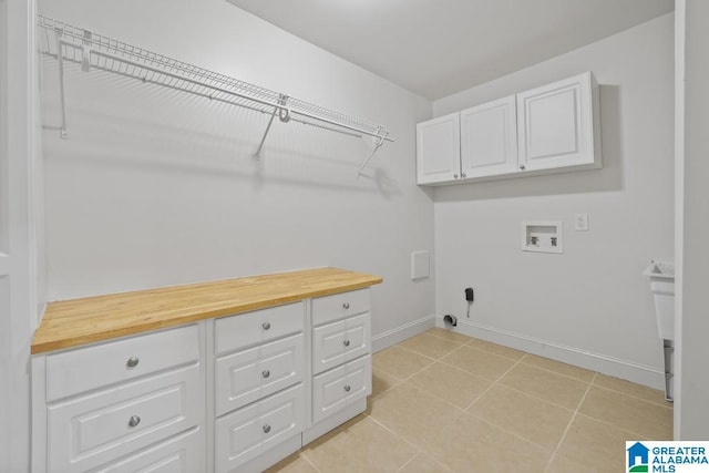 laundry area with washer hookup, cabinet space, baseboards, and light tile patterned floors