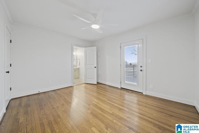 unfurnished bedroom featuring ensuite bath, baseboards, ornamental molding, and wood finished floors