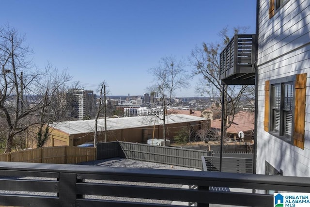 exterior space featuring a balcony, fence, and a city view