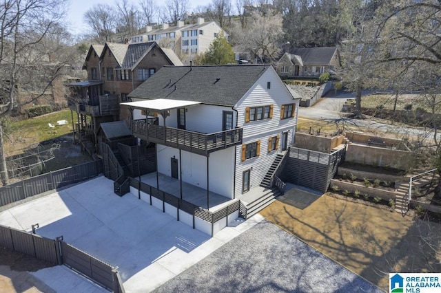 back of property featuring driveway, stairway, a patio area, and fence