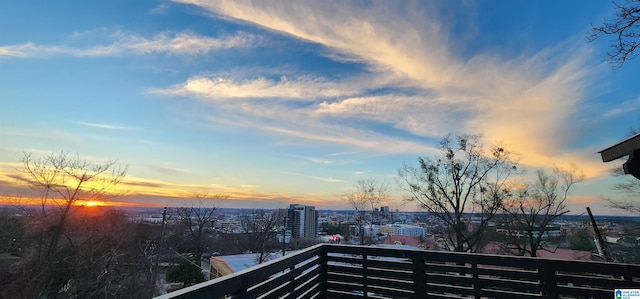 balcony at dusk featuring a city view