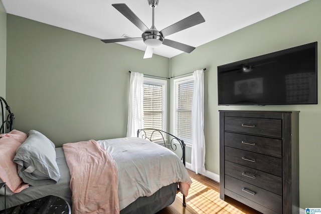 bedroom featuring ceiling fan, light wood finished floors, and baseboards