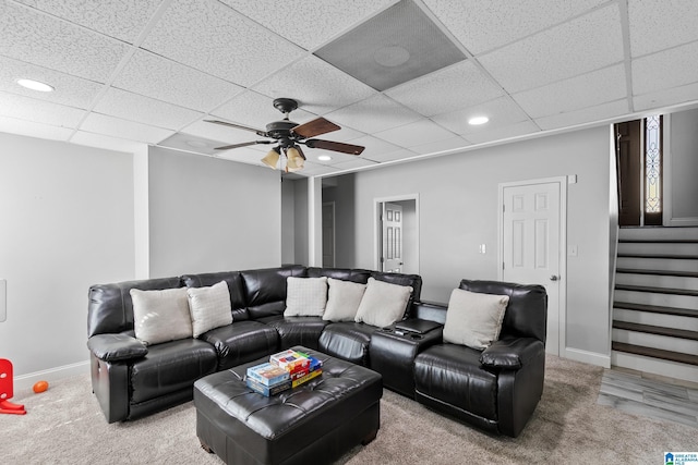 carpeted living area with a paneled ceiling, recessed lighting, a ceiling fan, baseboards, and stairway