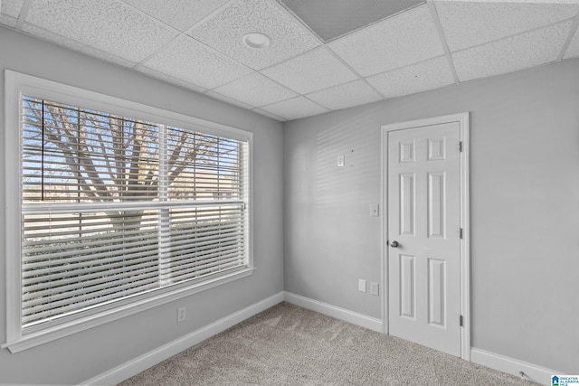 empty room featuring carpet floors, a paneled ceiling, visible vents, and baseboards