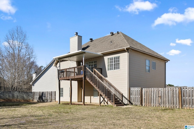 back of property with a deck, a fenced backyard, a yard, and stairway