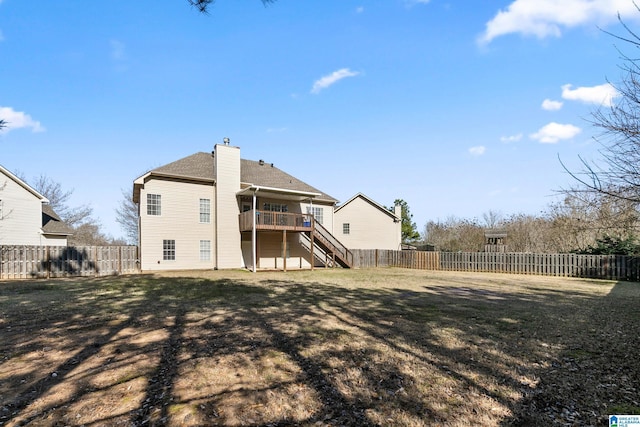 back of house featuring a fenced backyard, stairway, a lawn, a wooden deck, and a chimney