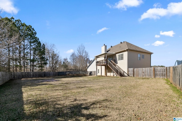 view of yard with a fenced backyard, a deck, and stairs