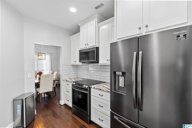 kitchen with stainless steel fridge, tasteful backsplash, visible vents, dark wood-type flooring, and range with electric stovetop