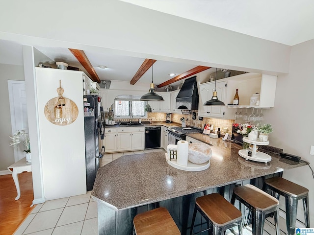 kitchen with tasteful backsplash, a peninsula, black appliances, premium range hood, and open shelves