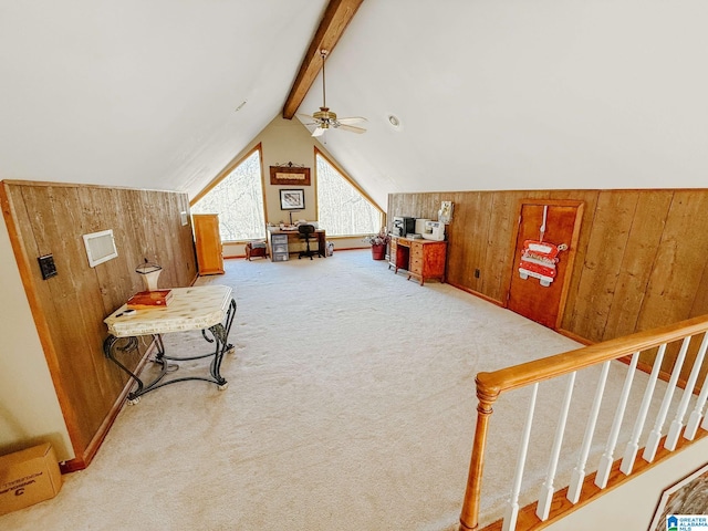 additional living space featuring lofted ceiling with beams, wood walls, carpet, and a ceiling fan