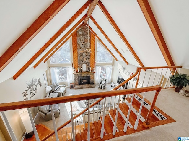 bonus room with stairway, beamed ceiling, a fireplace, and a wealth of natural light