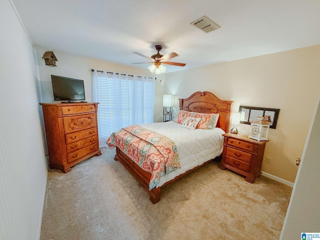 bedroom featuring ceiling fan, visible vents, baseboards, and light colored carpet