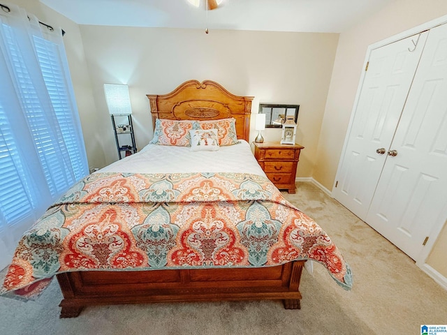 bedroom featuring light carpet, baseboards, and a closet