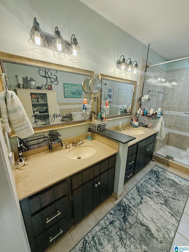 bathroom with a stall shower, two vanities, a sink, and tile patterned floors