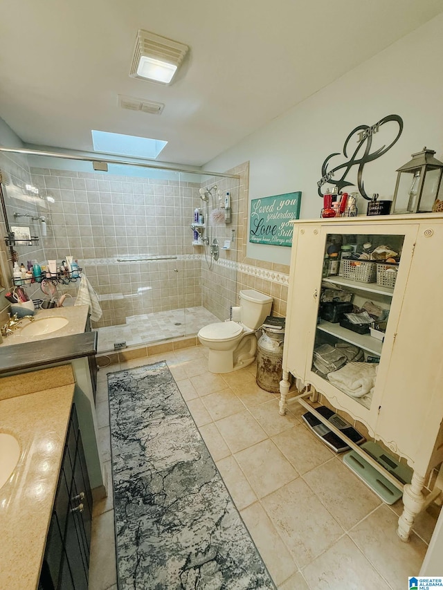 full bathroom with tile patterned flooring, toilet, vanity, tile walls, and a stall shower