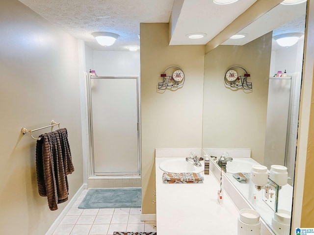 full bath featuring a stall shower, tile patterned flooring, a textured ceiling, and vanity