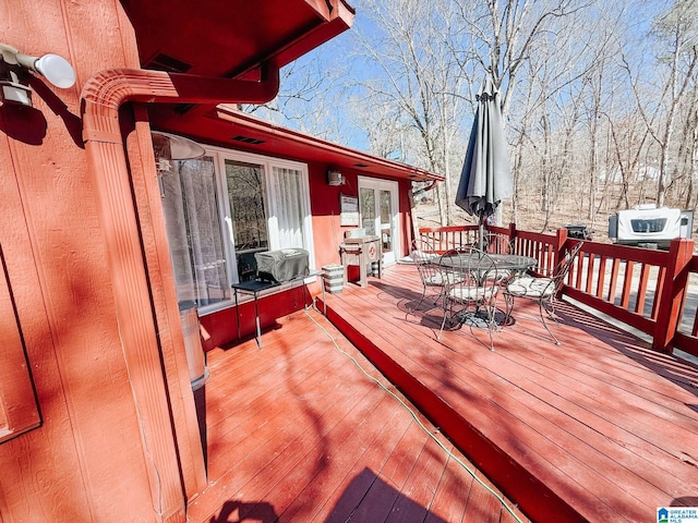 wooden deck with area for grilling and outdoor dining space