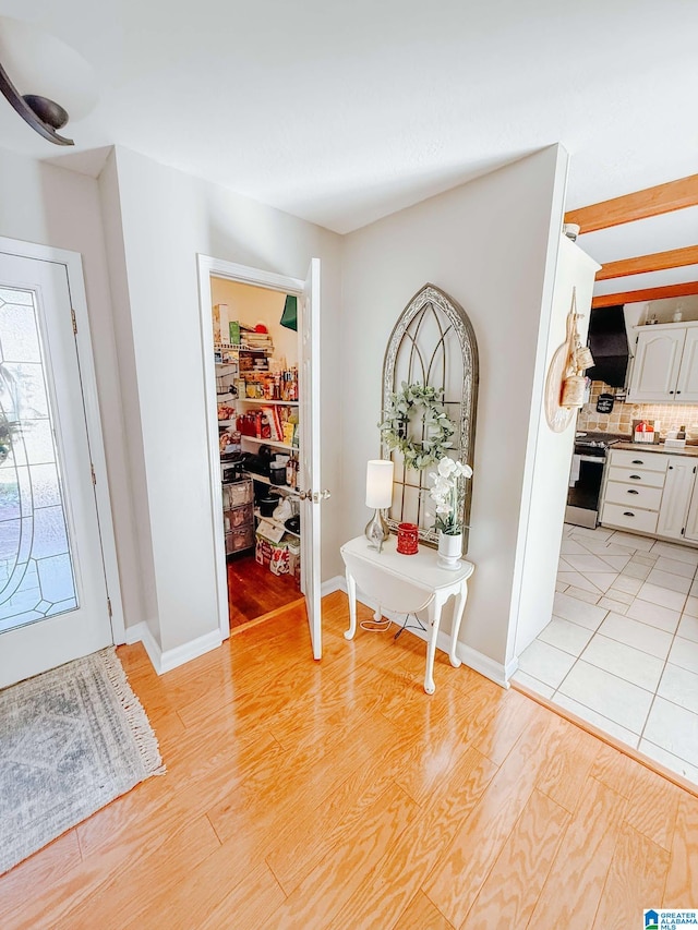 foyer featuring light wood-style floors and baseboards